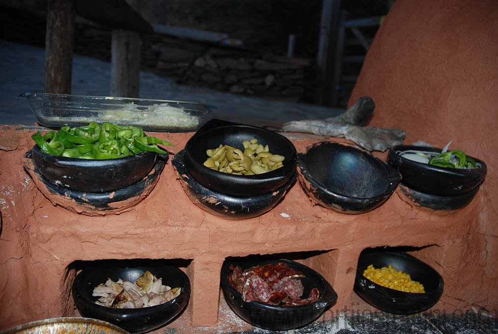 Pizza ingredients beside the clay oven